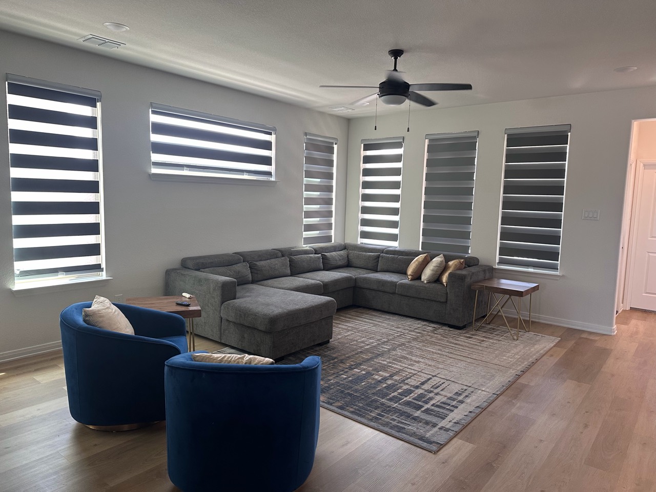 Airbnb living room with sectional and blue chairs