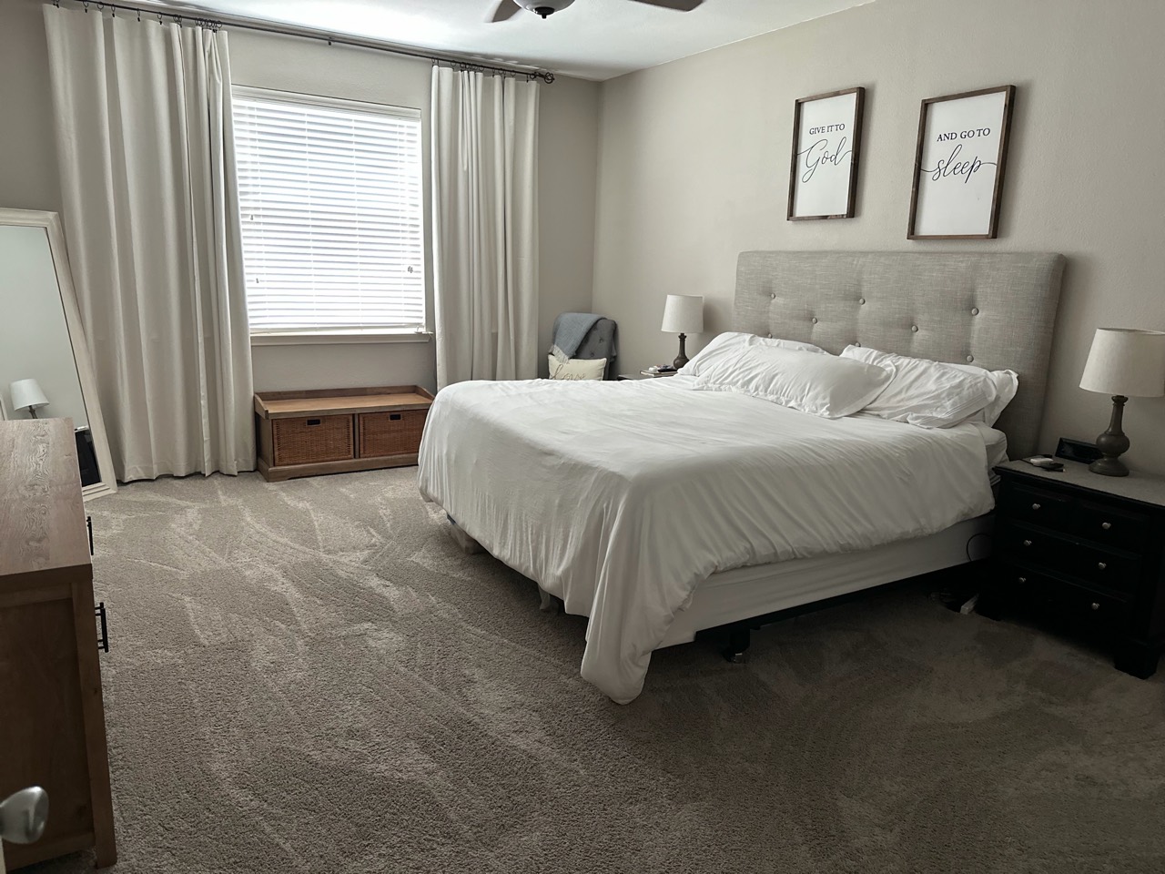 Bedroom with white bedding and vacuumed carpet